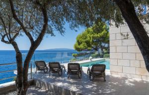 eine Reihe von Stühlen neben einem Pool in der Unterkunft Villa Toma by Villas Guide in Gornji Dingač