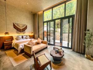 een slaapkamer met een bed, een bank en ramen bij LongSen Valley Inn in Zhukeng