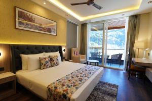 a bedroom with a large bed and a large window at Carom Hotel Manali in Manāli +80 photos