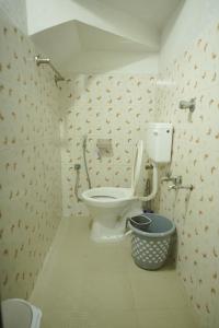 a bathroom with a toilet and a bucket in it at Tree Fort Homestay in Cochin +6 photos