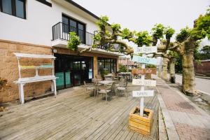 a patio with a table and chairs and street signs at Latas Surf Lodge in Loredo