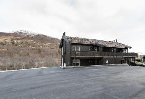 ein großes schwarzes Haus mit Balkon auf einem Grundstück in der Unterkunft Stranda Fjellgrend 3 bedrooms and loft - 80C in Stranda