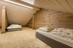 zwei Betten in einem Zimmer mit Holzwand in der Unterkunft Stranda Fjellgrend 3 bedrooms and loft - 80C in Stranda
