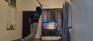 a man is playing a video game on the wii at Tree Fort Homestay in Cochin