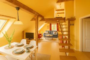 Lancken-GranitzにあるVogelhaus Gobbinの黄色の壁とらせん階段のあるリビングルーム