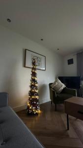 Seaside Serenity في ليانيلي: غرفة معيشة مع شجرة عيد الميلاد في غرفة معيشة