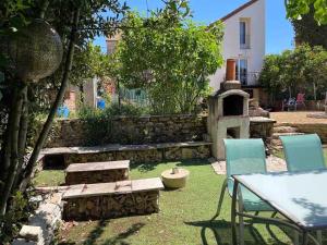 ein Garten mit Tisch und Stühlen und einer Feuerstelle in der Unterkunft Gîte L'Écrin - Maison de charme 8Pers - By Primo in Buxy