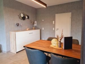 ein Esszimmer mit einem Holztisch und blauen Stühlen in der Unterkunft Eifel Dream Casa29 in Burbach