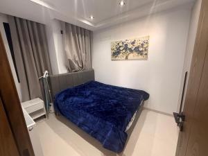 a small bedroom with a blue blanket on a bed at Appartement Luxe S2-900m-plage-Fibre-Smart TV-Parking privé in Nabeul