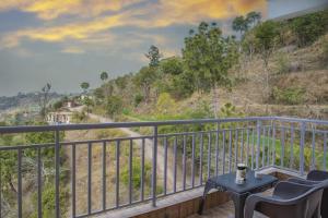 クフリにあるThe Himalayan Rootsの眺めの良いバルコニーにテーブルと椅子が置かれている