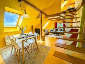 Lancken-GranitzにあるVogelhaus Gobbinの黄色の壁と木製の階段が特徴のリビングルーム