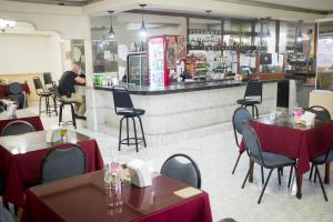 um restaurante com mesas e cadeiras e um homem parado num balcão em Hotel Latino na Cidade do Panamá