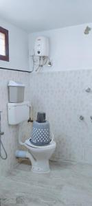 a bathroom with a toilet with a controller on it at Tree Fort Homestay in Cochin