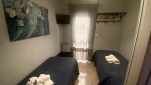 um pequeno quarto com duas camas e uma janela em Marifra Flats em Taormina mais 57 fotografias