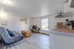 ein Wohnzimmer mit Sofa und eine Küche in der Unterkunft F2, near Disney in Guérard