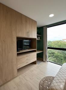 a living room with a tv and a large window at Zuba IV in Luque
