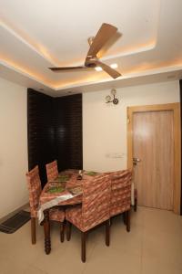 加济阿巴德Adriadna Homes City Comfort Stay Simple, Stylish Comfortable的一间带吊扇和桌椅的用餐室