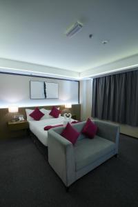 una grande camera d'albergo con un letto e un divano di The Airport Hotel Muscat a Mascate Altre 12 foto