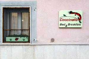 a sign on a building with a window and a sign at Coccinella B&B a Tufo in Tufo
