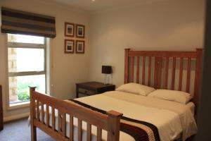 a bedroom with a wooden bed and a window at Sam's Place in Lake Tekapo