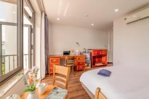 a bedroom with a bed and a desk and a kitchen at Sóng homestay 4 - The spacious house - In the Prime location in Da Nang