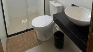 a bathroom with a white toilet and a sink at A 5 min da Praia-Vista Pôr do Sol · Piscina , Ar in Maceió +16 photos