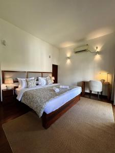 a bedroom with a large bed and a chair at Luxe Hideaway in Colombo