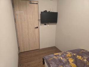 a door in a room with a bed and a television at Hao Chi Tao Hotel in Kaohsiung