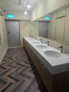 a bathroom with four sinks and a large mirror at Hao Chi Tao Hotel in Kaohsiung