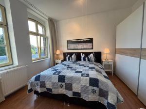 a bedroom with a bed with a checkered blanket at Ferienwohnung Bress OG in Ueckermünde