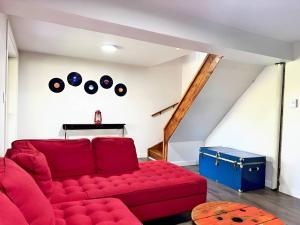 a red couch in a living room with a attic at Waterfront with Spa - Le Retro in Windsor