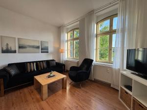 a living room with a black couch and a table at Ferienwohnung Bress OG in Ueckermünde