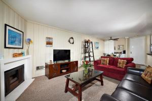 a living room with a red couch and a fireplace at North Coast Village D204 in Oceanside