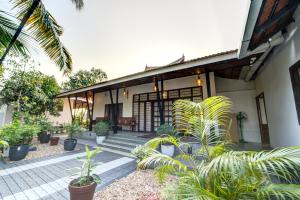 Breeze and Grains Resort 3-BHK Villa with Verandah & Outdoor Patio في Champakulam: امامه بيت فيه نباتات