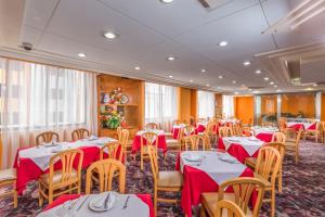 a dining room with tables and chairs with red table cloth at Hotel Estoril in Mexico City