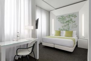 ein weißes Schlafzimmer mit Bett und Schreibtisch in der Unterkunft Room Mate Mario, Madrid in Madrid