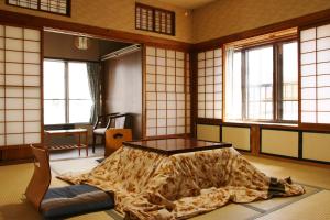 a room with a bed in a room with windows at Takasagoya Ryokan in Zao Onsen
