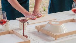 a person cutting wood on a table with wine glasses at Tenuta Doxi in Gallipoli