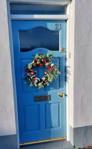 a blue door with a christmas wreath on it at The Innkeeper’s Lodge Bushmills in Bushmills