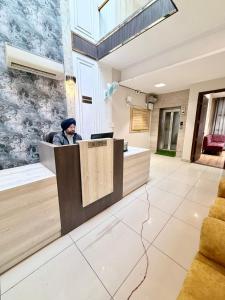a man sitting at a reception desk in a lobby at Hotel Maria in Dera Bassi +16 photos