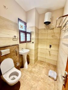 a bathroom with a toilet and a sink and a shower at Hotel Maria in Dera Bassi