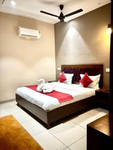 a bedroom with a bed with red and white pillows at Hotel Maria in Dera Bassi