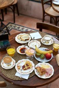 ein Tisch mit Tellern voller Frühstücksspeisen darauf in der Unterkunft Antigua Casona Bed & Breakfast in San Antonio de Areco + 20 Fotos