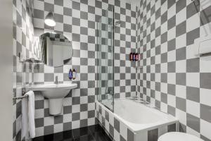 ein Badezimmer mit schwarz-weiß karierten Fliesen in der Unterkunft Room Mate Mario, Madrid in Madrid
