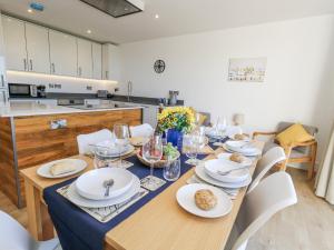 a dining room with a table with plates and wine glasses at Sea Fern House - 36B in Poole