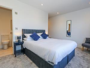a bedroom with a large bed with blue pillows at Sea Fern House - 36B in Poole