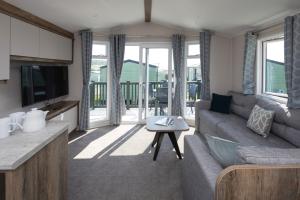 a living room with a couch and a table at Ruda Holiday Park in Croyde