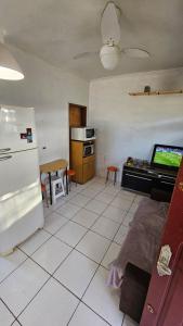 eine Küche mit einem Kühlschrank und einem Tisch mit einem TV in der Unterkunft Apartamento de 1 quarto próximo a praia - Com Estacionamento Rotativo in Tramandaí