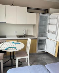 a small kitchen with a table and a refrigerator at Holiday season at sea in Shëngjin