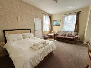 a bedroom with a large white bed and a couch at Deincourt Hotel in Newark upon Trent +71 photos